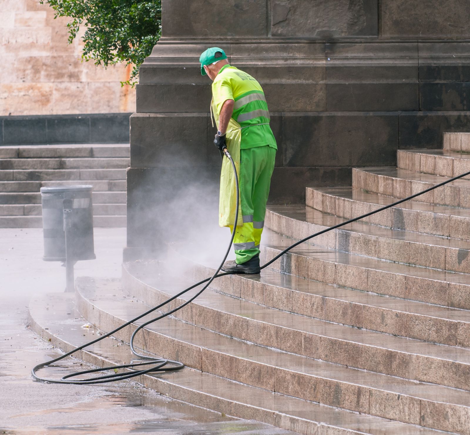 A worker pressure washing stone stairs, mist rising from the spray — illustrative stock photo, not A True Clean's own crew.