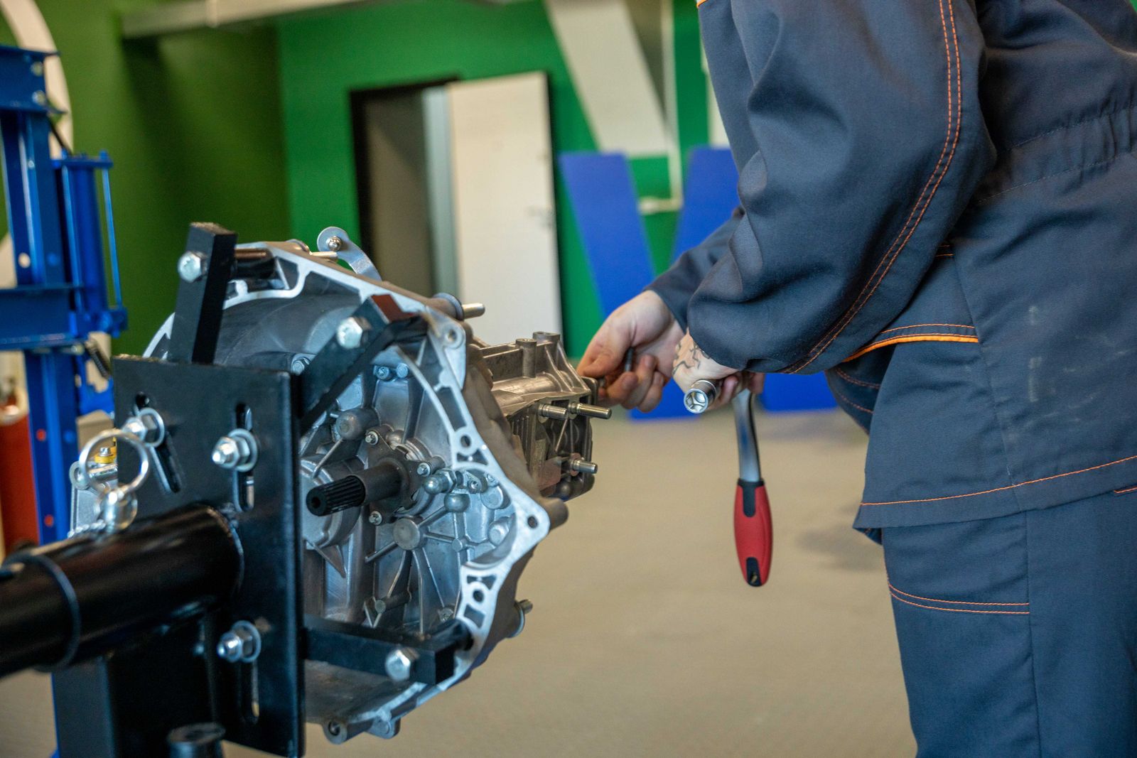 Illustrative stock photo of a mechanic working on a car transmission in a workshop — not A & K's own shop.