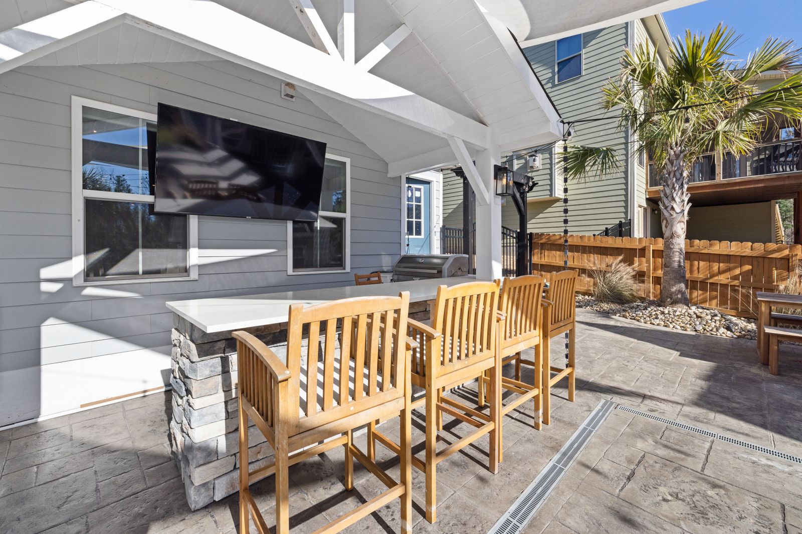 A spacious covered outdoor patio with wooden seating under a covered roof structure — illustrative stock photo, not a Bryan Awnings project.