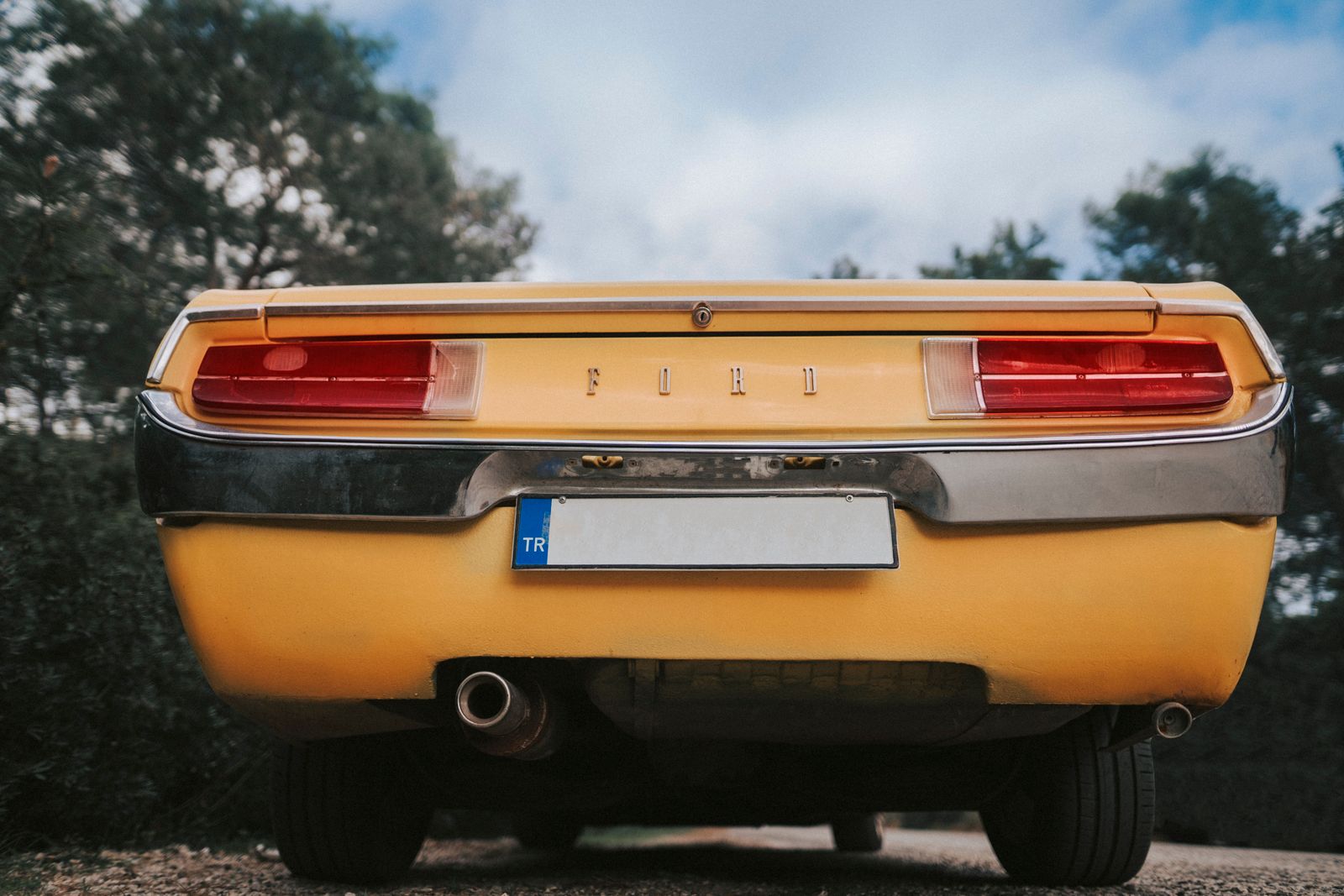 Rear view of a classic Ford with dual chrome exhaust tips — illustrative stock photo, not a photo of Bryan Muffler & Performance or its shop.