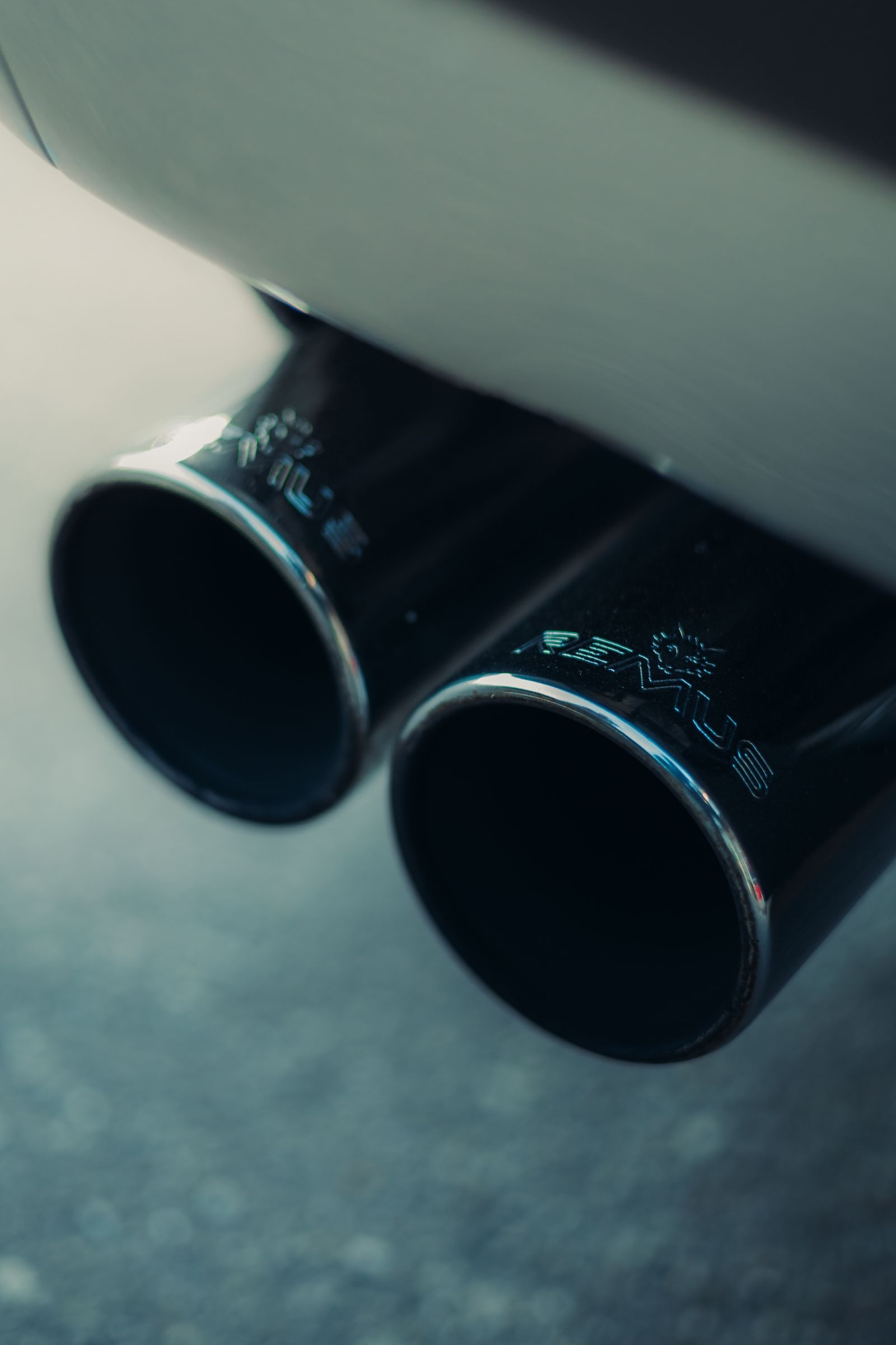 A detailed close-up of dual chrome exhaust pipes on a vehicle — illustrative stock photo, not a photo of Exhaust Works LLC or its work.