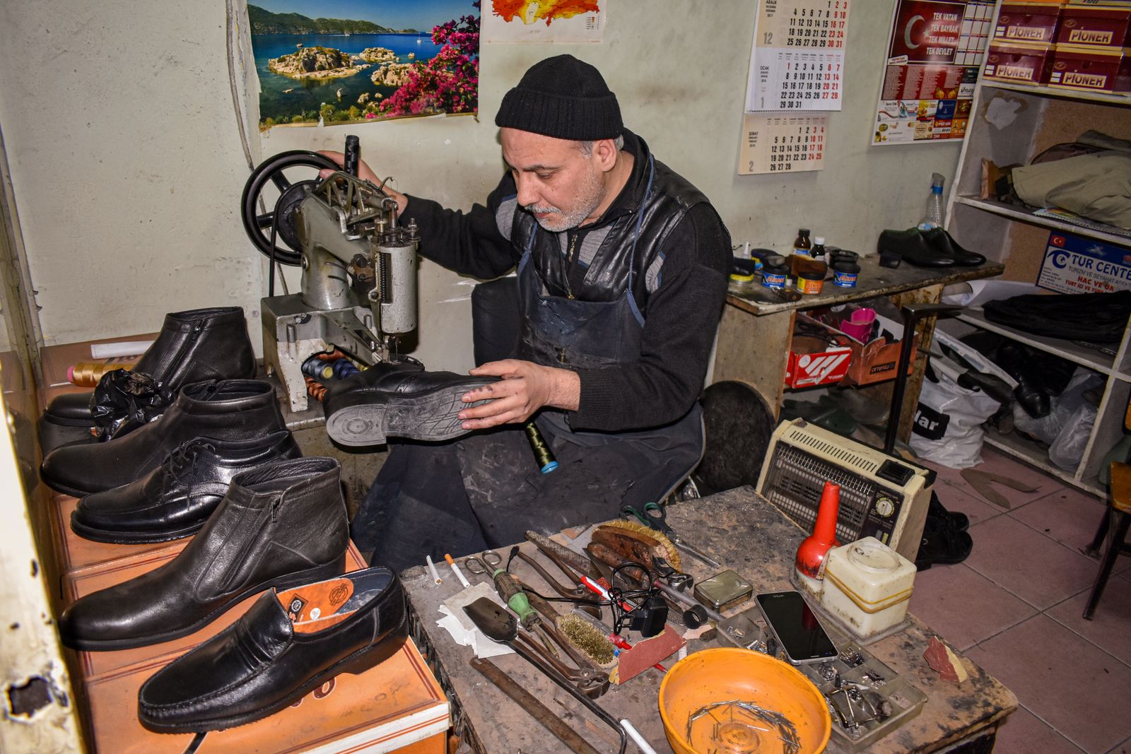 A cobbler meticulously repairing leather shoes in a traditional workshop setting — illustrative stock photo, not a photo of Gomez Shoe Repair or its staff.