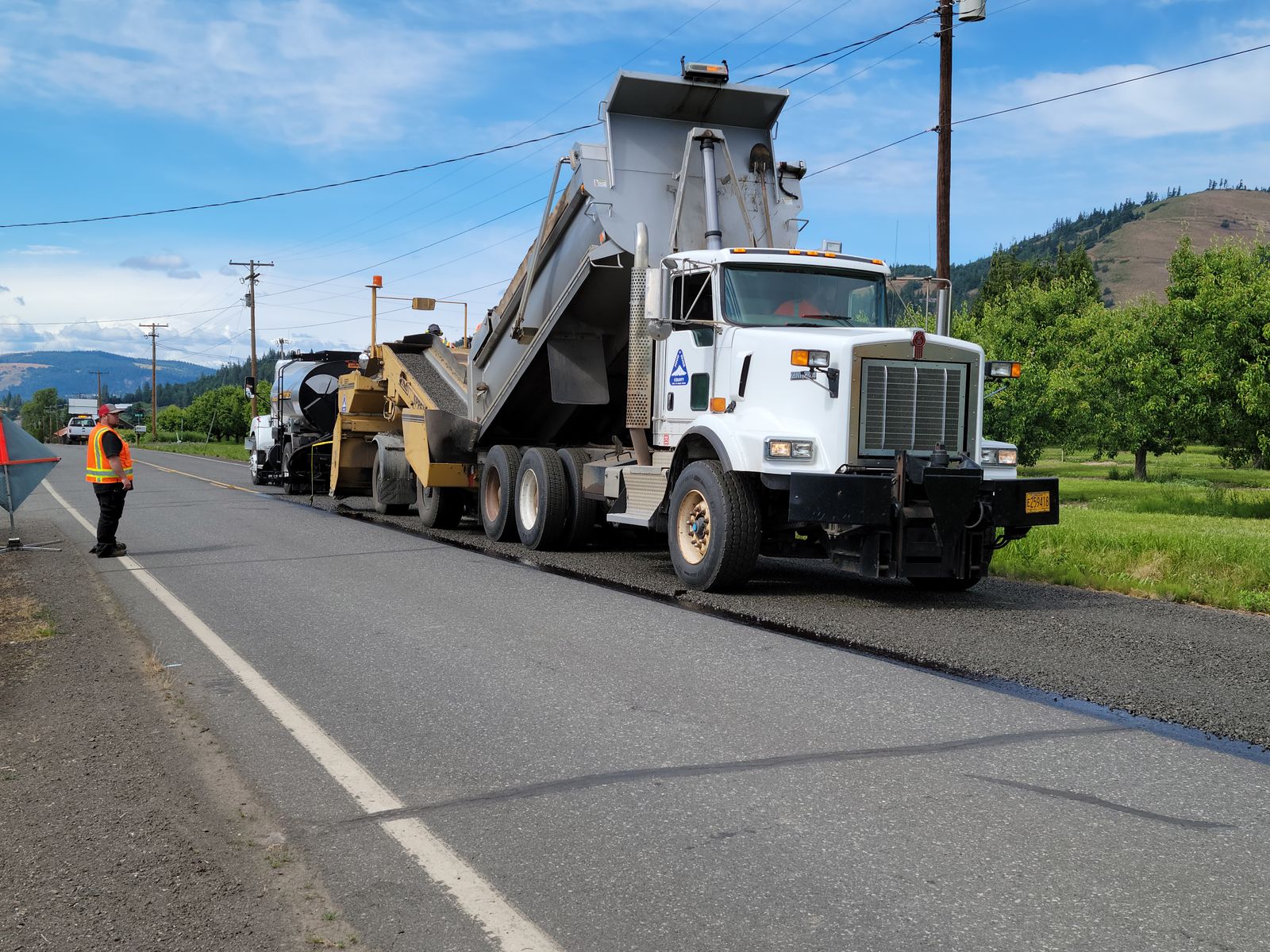 A paving crew and equipment working on asphalt road construction — illustrative stock photo, not J&W's own crew or equipment.