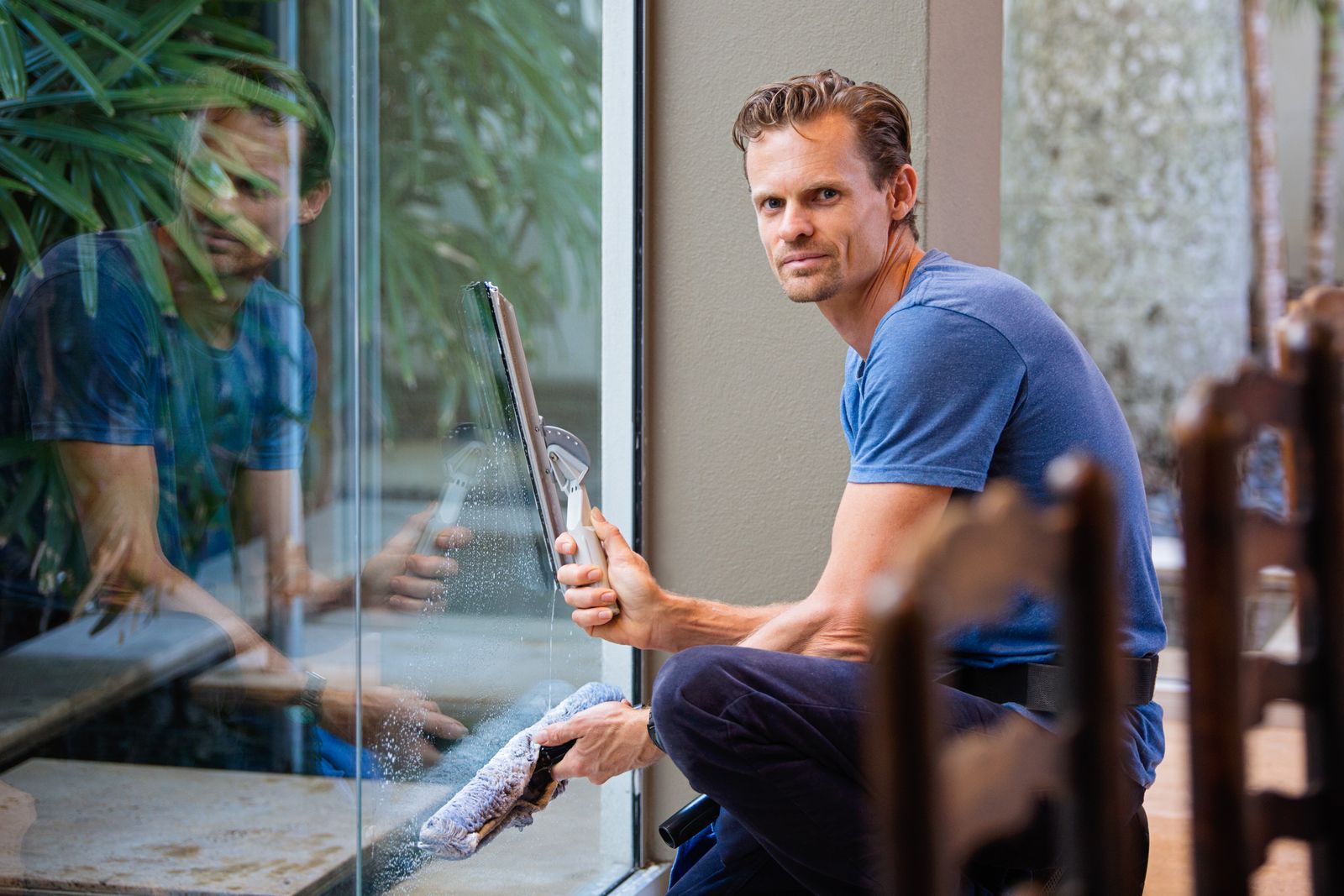 Close-up of a squeegee cleaning a large glass pane — illustrative stock photo, not Maxey Way's own equipment.