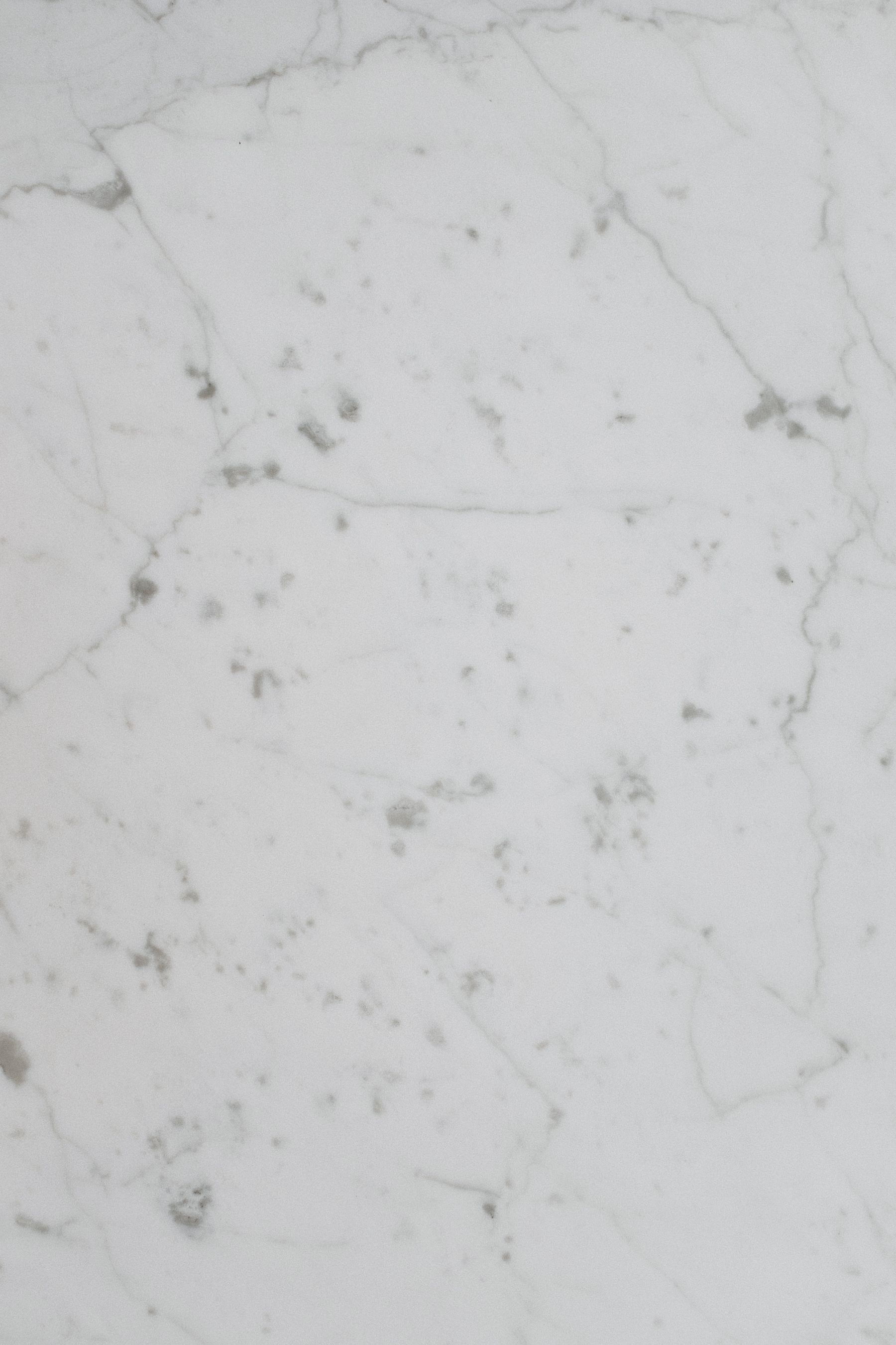 Close-up of white marble with subtle gray veining, illustrative stock photo