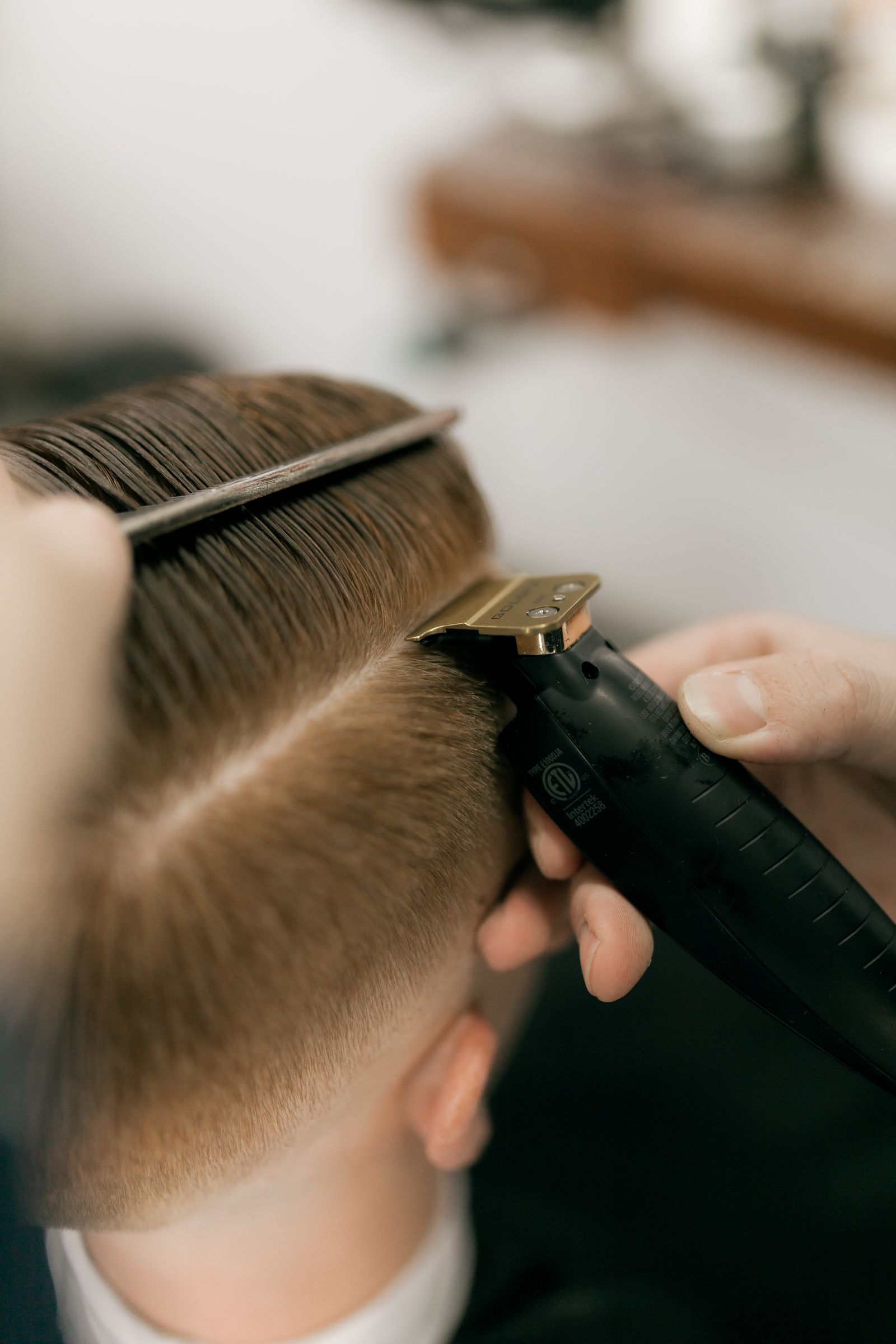 A barber giving a client a precise fade haircut with clippers and a comb — illustrative stock photo, not a photo of Neff's Majestic Hair Studio or its staff.