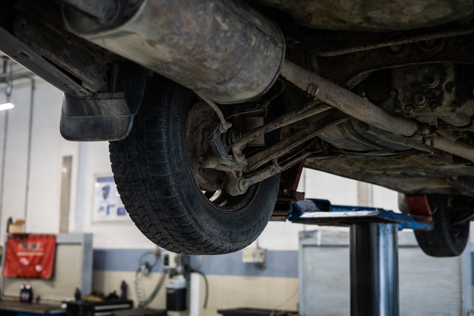 A close-up view of a car's undercarriage and exhaust system in a service station — illustrative stock photo, not a photo of Soto's Mufflers.